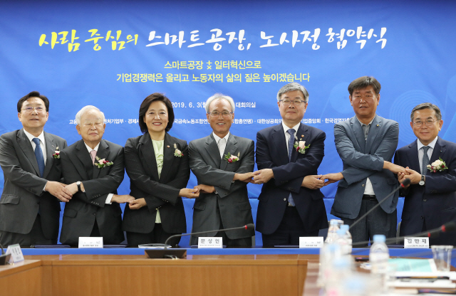 3일 서울 경제사회노동위원회에서 열린 ‘사람 중심의 스마트공장 확산을 위한 노사정 협약식’에서 노사정 관계자들이 협약서 서명 후 서로 손을 맞잡았다. 사진 왼쪽부터 김기문 중소기업중앙회 회장, 손경식 한국경영자총협회 회장, 박영선 중소벤처기업부 장관, 문성현 경사노위 위원장, 이재갑 고용노동부 장관, 김만재 한국노총 금속노련 위원장, 김준동 대한상의 상근부회장./연합뉴스