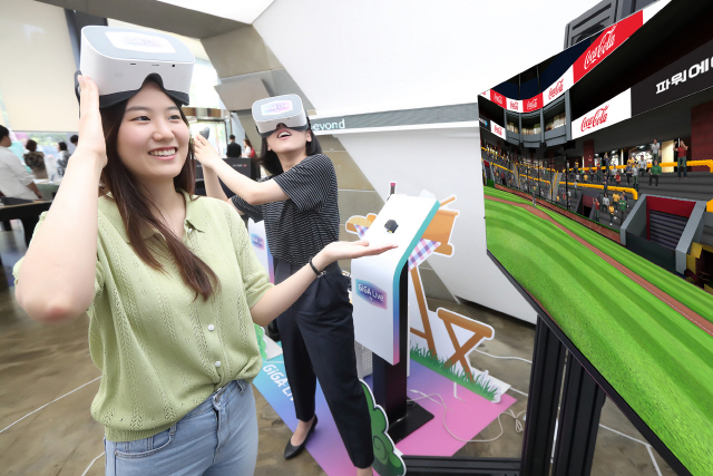 KT 모델들이 기가라이브TV를 이용해 VR 스포츠 게임을 즐기는 동안 게임 속 경기장 전광판에 코카콜라 광고가 나오고 있다./사진제공=KT