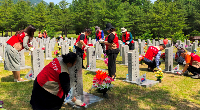 롯데백화점 대전점 샤롯데 봉사단이 국립대전현충원에서 비석닦기 등 봉사활동을 하고 있다. 사진제공=롯데백화점 대전점