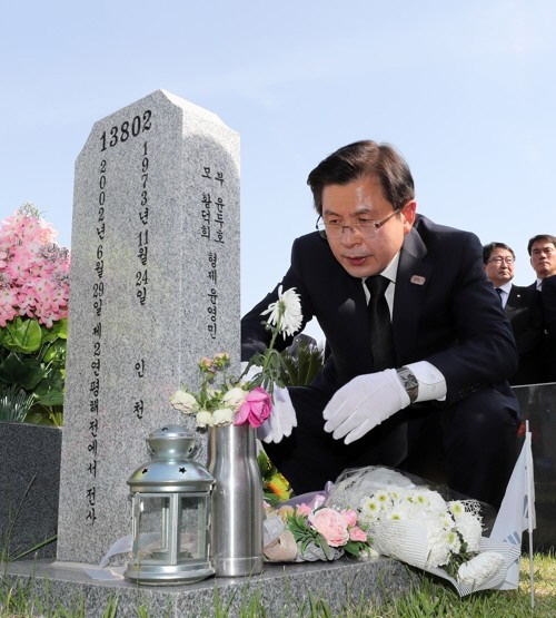 자유한국당 황교안 대표가 4일 오후 국립대전현충원 제2연평해전 포격 희생자 묘역을 찾아 참배한 뒤 묘비를 어루만지고 있다. /연합뉴스