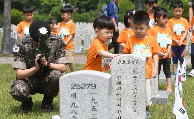 현충일을 하루 앞둔 5일 서울 국립현충원에 현장학습을 나온 어린이들이  6.25 전사자 묘지에서  참배하고 있다./이호재기자. 2019.06.05