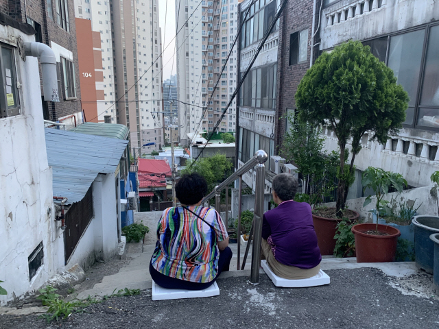 김미자 할머니(오른쪽)는 계단에 앉아 솔솔 불어오는 바람을 맞으며 친구와 수다를 나누는 게 즐거움이다. / 강신우 기자
