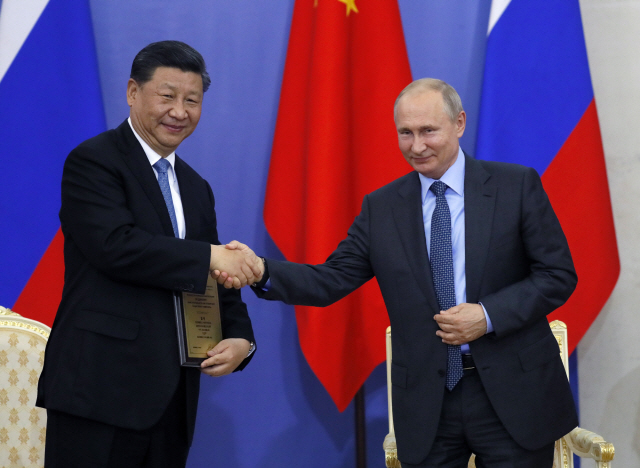 블라디미르 푸틴(오른쪽) 러시아 대통령이 6일(현지시간) 상트페테르부르크에서 시진핑 중국 국가 주석에게 상트페테르부르크국대립 명예박사 학위를 수여하며 악수하고 있다. /상트페테르부르크=EPA연합뉴스