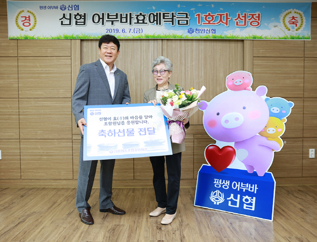 7일 충남 천안신협에서 열린 ‘어부바효예탁금 1호 가입자 축하행사’에서 김윤식(왼쪽) 신협중앙회장이 1호 가입자의 어머니에게 선물을 전달하고 있다./사진제공=신협중앙회