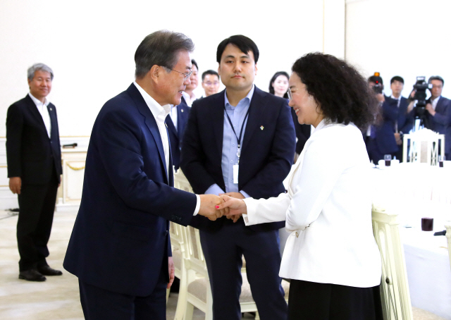 문재인 대통령이 7일 낮 청와대에서 열린 ‘국민께 힘이 되는 일 잘하는 공무원’ 초청 오찬에 입장하며 일본산 수산물 수입금지 관련 세계무역기구(WTO) 분쟁에서 승소하는 데 기여한 고성민(오른쪽) 당시 산업통상자원부 통상분쟁대응과 사무관과 인사하고 있다./연합뉴스