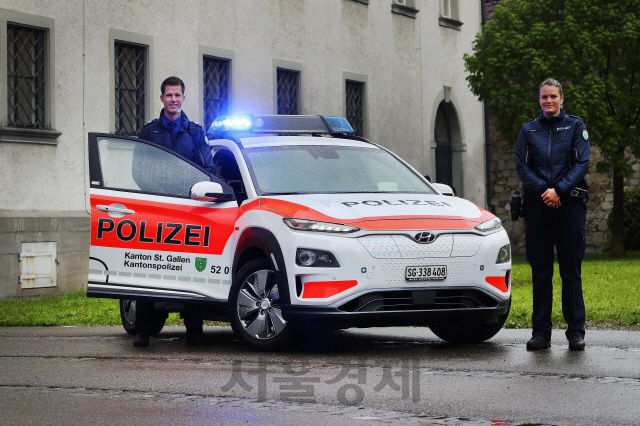 스위스 생 갈렌 주의 경찰들이 공식 경찰차로 선정된 현대자동차 코나 일렉트릭 옆에 서있다./사진제공=현대차