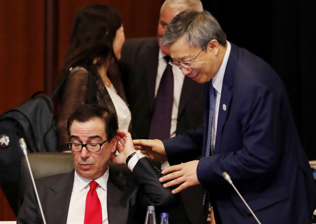 일본에서 주요20개국(G20) 재무장관 및 중앙은행총재 회의가 개최된 가운데 8일 이강(오른쪽) 중국 인민은행장이 스티븐 므누신 미 재무장관에게 웃으며 말을 걸고 있다.    /후쿠오카=AP로이터연합뉴스