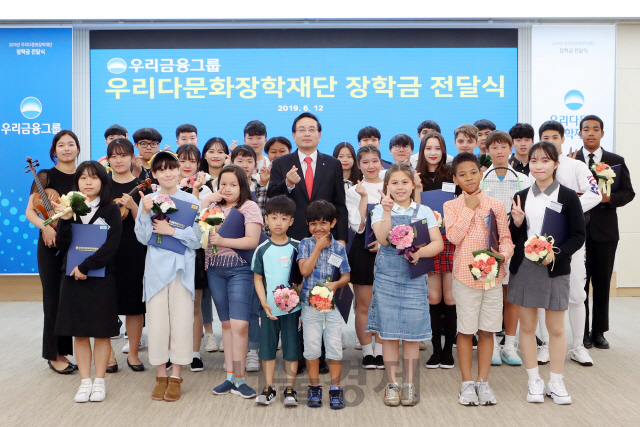 손태승(가운데) 우리금융그룹 회장이 12일 서울 중구 우리은행 본점에서 ‘2019년 다문화 학생 장학금 전달식’을 진행하고 장학생 대표들과 기념촬영을 하고 있다. 우리금융은 이날 다문화 장학생 400명에게 총 6억3,000만원의 장학금을 전달했다. /사진제공=우리금융지주