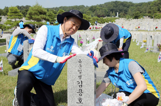 진옥동(왼쪽) 신한은행장과 임직원들이 12일 동작구 국립 현충원을 찾아 헌화와 함께 순국 선열들의 묘역을 일일이 정비하고 있다. 신한은행은 호국영령을 기리고 기업의 사회적 책임을 실천하기 위해 2010년부터 매년 현충원을 찾아 묘역정화 봉사를 하고 있다. /사진제공=신한은행