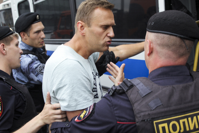 12일(현지시간)러시아 모스크바에서 경찰들이 탐사 전문기자 이반 골루노프를 체포한 경찰에 항의하는 시위에 참여한 야권 운동가 알렉세이 나발니를 연행하고 있다. /모스크바=AP연합뉴스