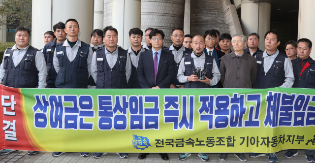 지난 2월22일 기아자동차 노동자들이 사측을 상대로 낸 통상임금 청구 소송 항소심에서 일부 승소한 후 서울 서초구 고등법원 앞에서 기자회견을 하고 있다./연합뉴스