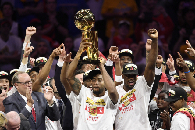 카와이 레너드(가운데)와 토론토 선수들이 14일 NBA 우승 트로피를 들고 환호하고 있다. /오클랜드=AP연합뉴스