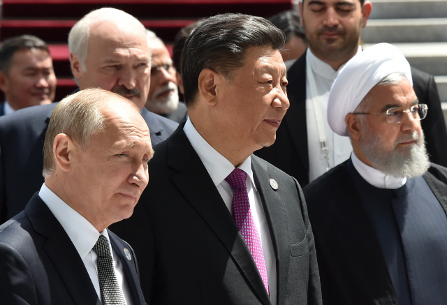 14일(현지시간) 키르기스스탄 비슈케크에서 열린 상하이협력기구(SCO) 정상회의에 참석한 블라디미르 푸틴(왼쪽부터) 러시아 대통령과 시진핑 중국 국가주석, 하산 로하니 이란 대통령이 나란히 걷고 있다. /비슈케크=AFP연합뉴스