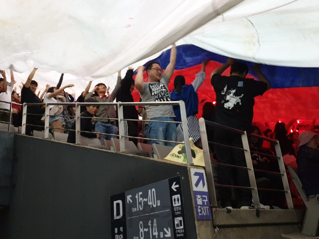 16일 서울 마포구 상암월드컵경기장을 찾은 시민들이 경기 시작에 앞서 대형 태극기를 펼치고 있다./허진 기자