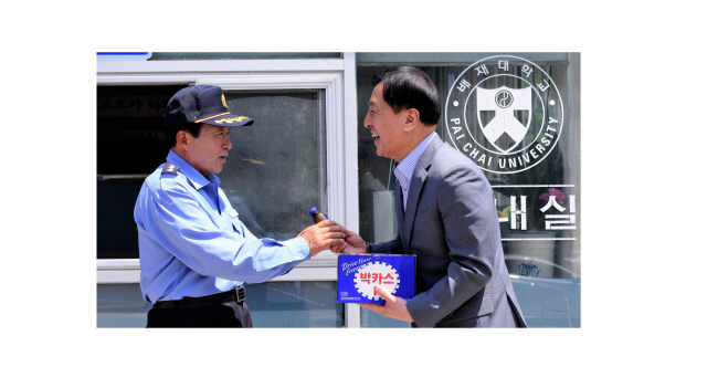 배재대에 발전기금을 전달한 경비원 조동주(왼쪽)씨가 17일 김선재 총장으로부터 감사의 표시로 음료수를 건네받고 있다. /사진제공=배재대