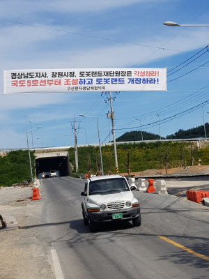 마산로봇랜드가 다음 달 개장을 앞두고 있는 가운데 창원시 마산합포구 구산면에 조속한 도로 인프라 구축을 촉구하는 현수막이 내걸려 있다./창원=황상욱기자