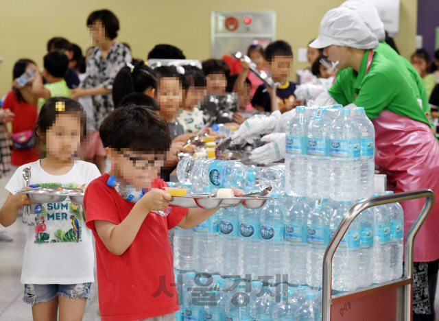 17일 ‘붉은 수돗물’ 사태를 겪고 있는 인천시 서구의 한 초등학교 급식실에서 학생들이 점심시간에 생수를 받기 위해 줄을 서 있다.      /인천=권욱기자