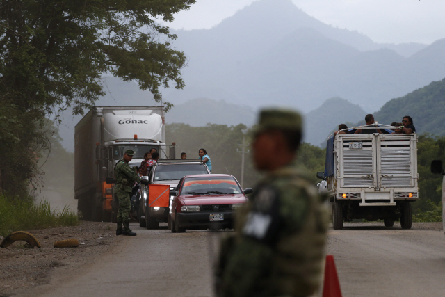 멕시코 군인들이 지난 15일(현지시간) 치아파스주 북부 쿠아우테목에 있는 임시 검문지점에서 차량들을 검문하고 있다.  /쿠아우테목=AP연합뉴스