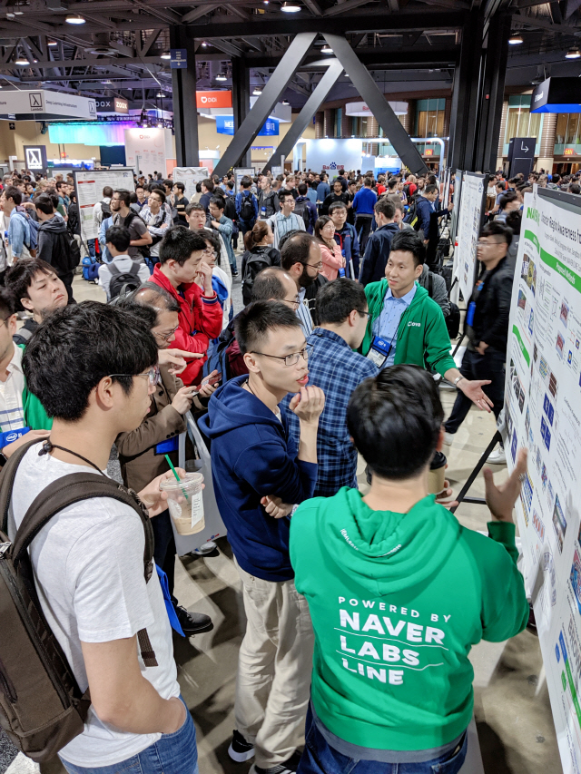 지난 16일부터 20일까지 미국 캘리포니아에서 진행된 인공지능 학술대회 ‘CVPR 2019’에 마련된 네이버 포스터 발표 섹션에서 참가자들이 연구에 대한 설명을 듣고 있다./사진제공=네이버
