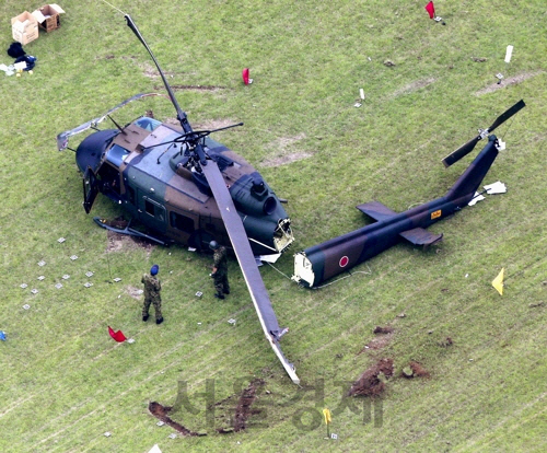 21일 오전 10시께 도쿄 다치카와(立川)시에 있는 육상자위대 기지에서 불시착 사고를 낸 UH1 헬기 모습. 꼬리 날개로 연결되는 동체가 두 동강 날 정도로 기체가 크게 파손됐다./연합뉴스
