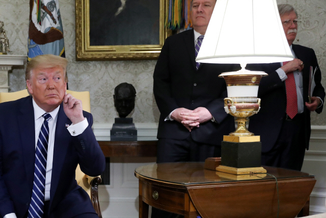 20일(현지시간) 백악관 집무실에 앉아 있는 도널드 트럼프(왼쪽) 미국 대통령의 뒤에 마이크 폼페이오(〃 두번째) 국무장관과 존 볼턴(〃 세번째) NSC 보좌관이 서 있다. /워싱턴DC=로이터연합뉴스