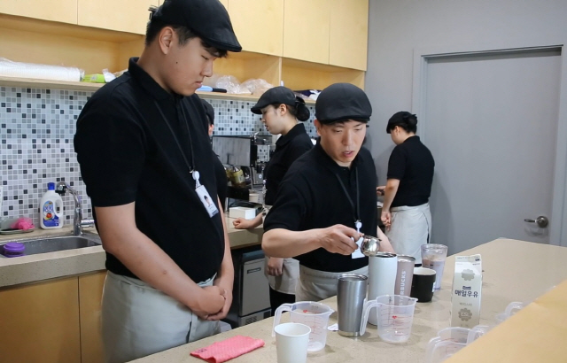 SK이노베이션의 자회사형 장애인 표준사업장 ‘행복키움’이 운영하는 ‘카페 행복’에서 장애인 근로자들이 바리스타 교육을 받고 있다. /사진제공=SK이노베이션