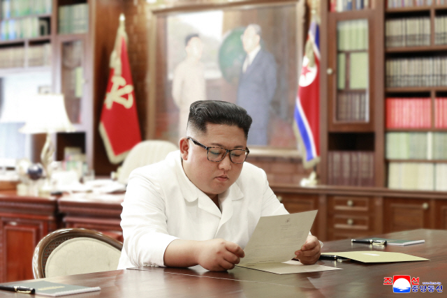 김정은 북한 국무위원장이 도널드 트럼프 미국 대통령의 친서를 읽고 있는 모습을 조선중앙통신이 23일 보도했다. /연합늇뉴스