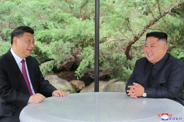 시진핑 중국 국가주석과 김정은 북한 국무위원장이 21일 평양 금수산영빈관에서 산책 중 자리에 앉아 대화를 나눴다고 조선중앙통신이 22일 보도했다.