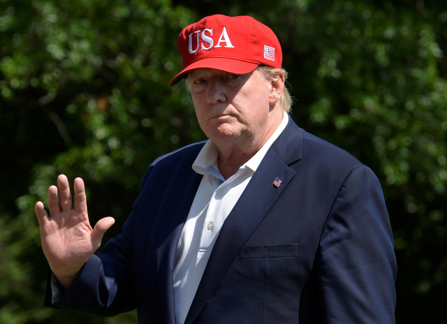 ‘미국’이라고 적힌 빨간 모자를 쓴 도널드 트럼프 미국 대통령이 23일(현지시간) 백악관으로 들어서면서 기자들에게 인사하고 있다. /워싱턴DC=로이터연합뉴스