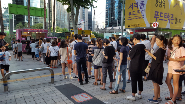 시민들이 서울 강남역 인근에 조성된 ‘푸드트럭 특화거리’에서 길거리 음식을 사기 위해 줄 서 있다./사진제공=서울시