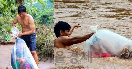 베트남 디엔비엔성의 한 마을에서 한 남성이 학교에 가는 아이를 비닐봉지에 담아 강을 건너고 있다. /연합뉴스