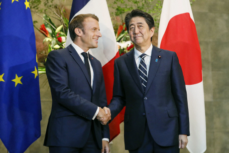 아베 신조(오른쪽) 일본 총리와 에마뉘엘 마크롱 프랑스 대통령이 26일 일본 도쿄 총리관저에서 정상회담후 악수를 나누고 있다.    /도쿄=교도연합뉴스