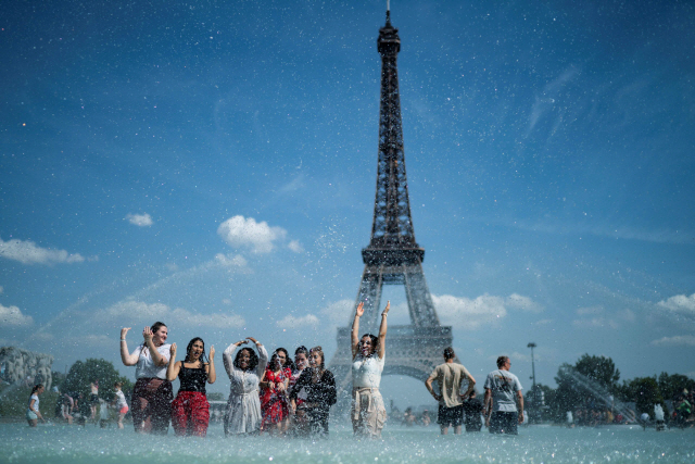 25일(현지시간) 프랑스 파리 시민들이 트로카데로 광장 분수에서 에펠탑을 배경으로 더위를 식히고 있다. /파리=AFP연합뉴스