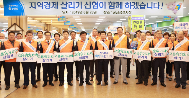 28일 전북 군산공설시장에서 열린 ‘지역경제 살리기 가두 캠페인’에서 김윤식(앞줄 오른쪽 다섯번째) 신협중앙회장이 임직원들과 신협의 특별지원사업을 홍보하고 있다./사진제공=신협중앙회