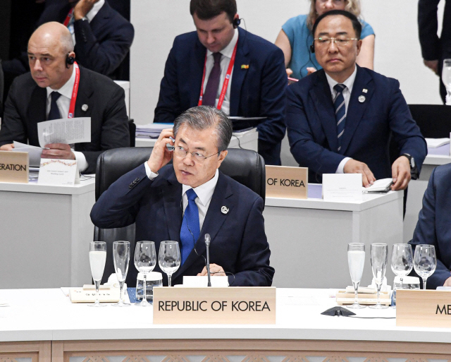 문재인 대통령이 28일 오후 인텍스 오사카에서 열린 G20 정상회의 세션1에서 헤드셋을 착용하고 있다./연합뉴스