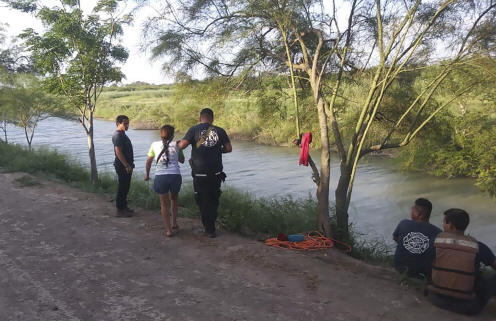멕시코 접경지역인 마타모로스 강가에서 엘살바도르 출신의 타니아 바네사 아발로스(가운데 왼쪽)가 지난 23일(현지시간) 멕시코 당국자에게 남편과 2살난 딸이 리오그란데 강을 건너다 급류에 휩쓸려 숨진 정황을 설명하고 있다. 강을 건너 미국으로 가려던 이들의 시신은 이튿날 아침 휩쓸려간 곳에서 수백 미터 떨어진 곳에서 딸이 아빠의 셔츠에 몸을 넣고 팔로 아빠의 목을 감싼 모습으로 발견됐다.     /마타모로스=AP연합뉴스