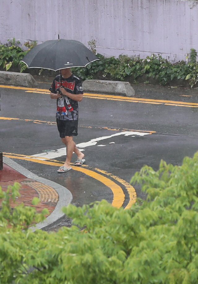 경남 일부 지역에 호우주의보가 발효된 29일 오후 우산을 쓴 시민이 창원시 마산합포구 거리를 걷고 있다. /연합뉴스