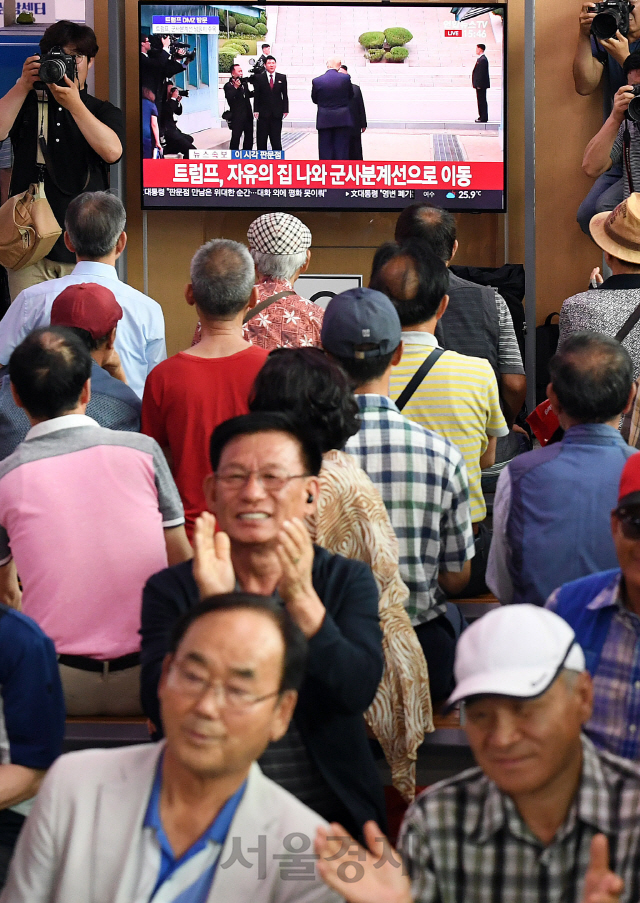 30일 오후 서울역에서 시민들이 도널드 트럼프 미국 대통령과 김정은 북한 국무위원장이 군사분계선에서 만나는 역사적인 순간을 TV를 통해 시청하고 있다./오승현기자 2019.6.30