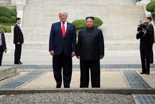 도널드 트럼프(왼쪽) 미국 대통령과 김정은 북한 국무위원장이 30일 오후 판문점 군사분계선 북측 지역에서 이뤄진 역사적인 미중 정상 간 만남에서 인사를 나눈 뒤 남측 지역으로 이동하기 전 기념촬영을 하고 있다. /판문점=연합뉴스