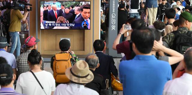 30일 오후 서울역에서 시민들이 문재인 대통령과 도널드 트럼프 미국 대통령, 김정은 북한 국무위원장이 군사분계선에서 만나는 역사적인 순간을 TV를 통해 시청하고 있다./오승현기자 2019.6.30