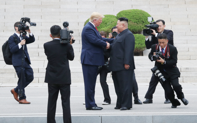 도널드 트럼프 미국 대통령과 김정은 북한 국무위원장이 30일 판문점 군사분계선 북측 지역에서 인사하고 있다. /연합뉴스