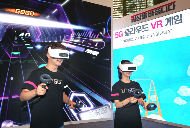 LG유플러스 직원들이 전용 기기를 머리에 착용하고 5G 클라우드 VR 게임을 즐기고 있다./사진제공=LG유플러스