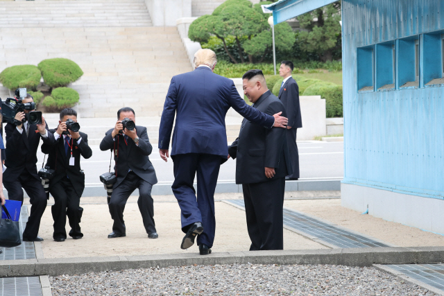 도널드 트럼프 미국 대통령이 30일 오후 판문점에서 김정은 북한 국무위원장과 만나 인사한 뒤 군사분계선을 넘어 북측으로 향하고 있다./연합뉴스