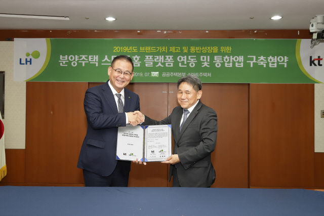 이필재(오른쪽) KT 마케팅부문장(부사장)과 김한섭 LH 공공주택본부장이 경기도 성남시 LH 경기지역본부에서 ‘2019년도 분양주택 스마트홈 플랫폼 연동 및 통합앱 구축협약’을 체결한 뒤 악수하고 있다. 양사는 올해 경기지역 2만1,000세대에 AI 스마트홈 서비스를 적용한다./사진제공=KT