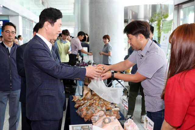 철도공단 김상균(사진 왼쪽 첫번째)이 2019 사랑나눔 바자회에서 물품을 구입하고 있다. 사진제공=한국철도시설공단