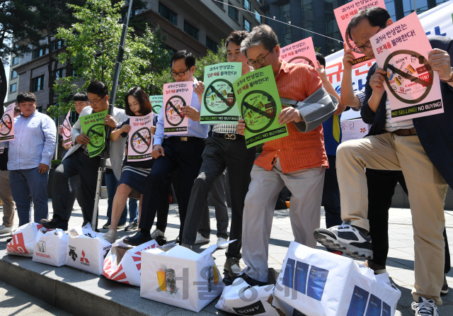 중소상인과 자영업자들이 지난 5일 서울 종로구 옛 주한 일본대사관 앞에서 열린 기자회견에서 일본제품 판매중지 돌입 및 불매운동을 선언하며 일본제품의 로고가 붙어있는 종이상자를 밟는 퍼포먼스를 하고 있다./성형주기자