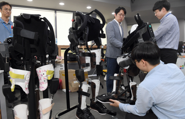 공경철(왼쪽 두번째) 엔젤로보틱스 대표와 연구진이 서울 신수동 본사에서 하지장애인의 직립보행을 돕는 웨어러블로봇 ‘엔젤슈트’를 정비하고 있다. /이호재기자