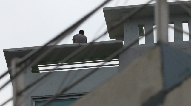 8일 오후 경남 거제시 옥포동 한 주상복합아파트 옥상에서 박모(45)씨가 경찰과 대치하고 있다/연합뉴스