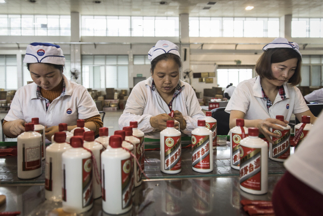 구이저우마오타이의 직원들이 마오타이주의 상징인 붉은띠를 묶는 작업을 하고 있다. 마오타이주는 원료제조를 비롯, 술빚기·저장·배합·포장 등 전통적 생산방식을 엄격하게 지키며 브랜드 가치를 유지하고 있다.   /블룸버그