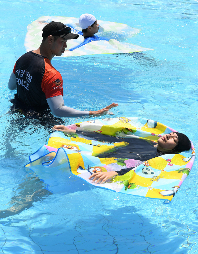생존수영강습에 참여한 인수중학교 학생들이 지난 4일 서울 여의도 야외수영장에서 돗자리를 이용해 물에 뜨는 방법을 배우고 있다./오승현기자